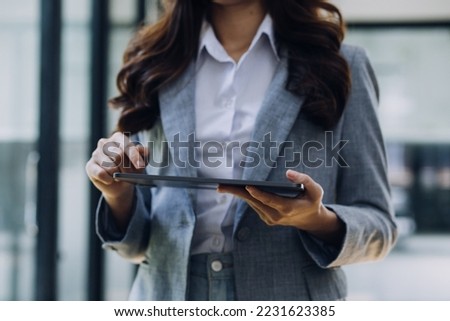Woman hand using smart phone and laptop in outdoor nature park and sunset sky with bokeh light abstract background. Technology business and freelance working concept. Vintage tone filter color style.