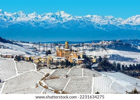 View of small medieval town on the hill covered with snow as mountains on background in the winter in Piedmont, Northern Italy. Royalty-Free Stock Photo #2231634275