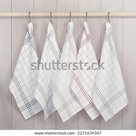 Kitchen towels hanging on wooden background Royalty-Free Stock Photo #2231634367