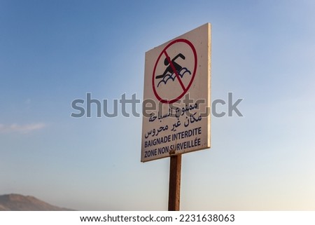 No swimming zone at the beach. Amazigh, Arabic, French and English writing on the sign