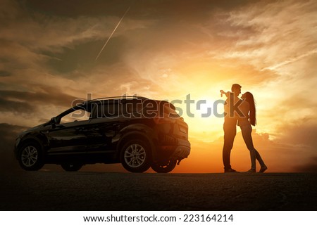 Silhouette of happiness couple stay near the new car under sky Royalty-Free Stock Photo #223164214