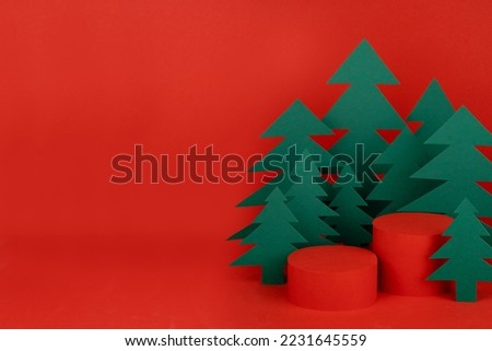 Christmas tradition background - two red scene, cylinder podiums mockup for presentation gifts, cosmetic products, good, green paper spruce forest, closeup. New year template for card, poster, flyer.