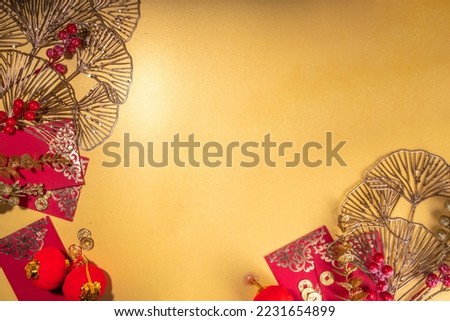 Chinese New Year gold red background. Lunar New Year greeting card flatlay with traditional festival decoration - ginkgo biloba branches decor, twigs, berries, gift envelopes, coins, Chinese lanterns Royalty-Free Stock Photo #2231654899