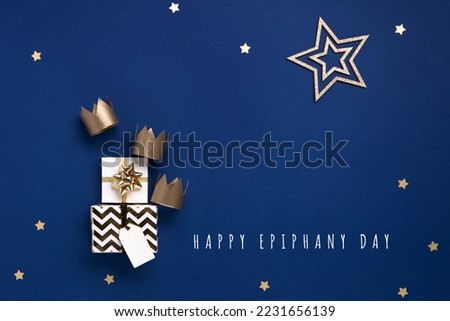 Traditional Three King's Day of January 6. Three gold crowns on blue background. Concept for Dia de Reyes Magos day, three Wise Men. Happy Epiphany day. Top view, copy space, flat lay. Royalty-Free Stock Photo #2231656139