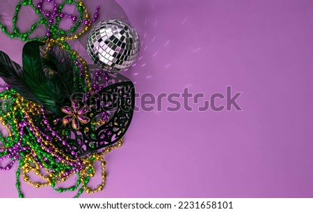 background for Mardi Gras with purple, green and yellow beads, carnival mask and disco ball
