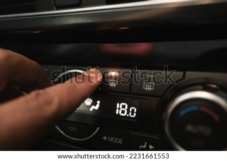 Windshield Defogger Icon on Car.  hand pressing the defogger button to remove the fog on the windshield Royalty-Free Stock Photo #2231661553