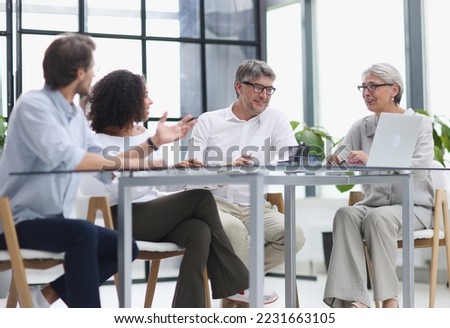 Serious team of professionals, business people negotiating in modern boardroom
