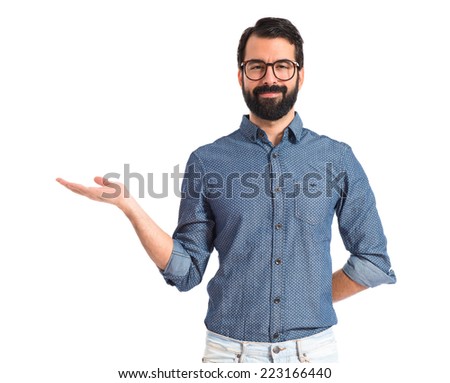 Young hipster man holding something over white background