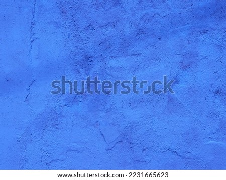 Surface is blue with fancy texture. Cracks, rough surface. Roughly plastered wall of old house. Abstract Grunge background for creative design. Copy space.

