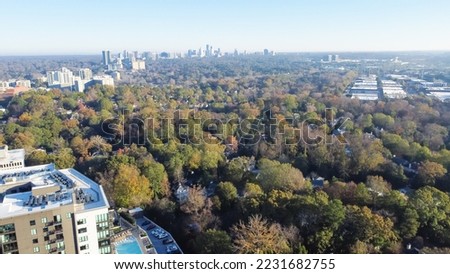Typical apartment condo building with swimming pool in Brookwood Hills neighborhood surrounded by colorful fall foliage autumn leaves and downtown Atlanta background aerial view. Sunny clear blue sky