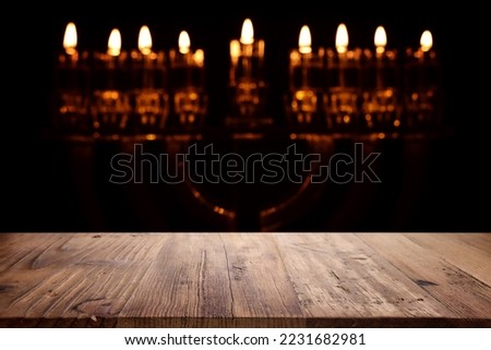 religion image of empty wooden table in front of jewish holiday Hanukkah background with menorah (traditional candelabra). For product display
