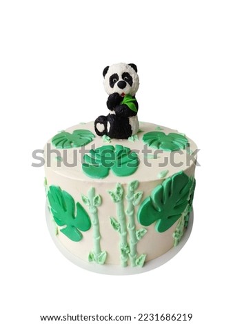 Cream cake with a figure of a panda and tropical monstera leaves isolated on white background