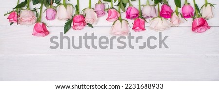 Flowers on white wooden background banner. Roses border.