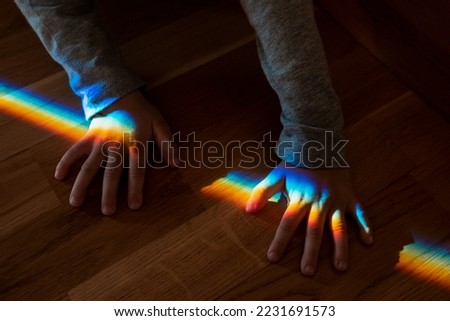Natural rainbow on the palm of a child. Refraction of light. High quality horizontal photo