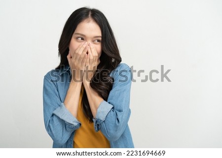 Young woman feeling embarrassed covering her face with her hands Royalty-Free Stock Photo #2231694669