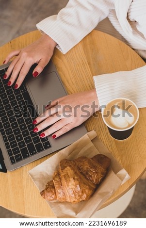 Pictures of women's hands holding a paper cup of coffee. Coffee to go concept. Top view of laptop computer. Freelance work.