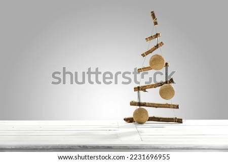 White wooden table of free space and christmas tree decoration. Gray wall background and empty place for your product. 