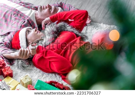 A young couple is celebrating their Christmas together happily at home.