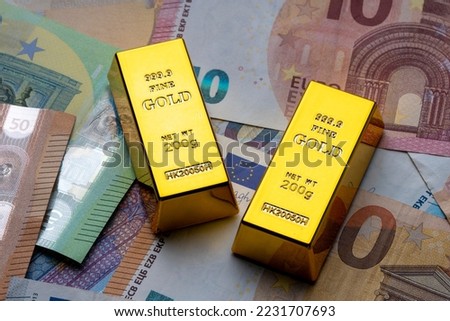 Euro banknotes and gold ingots close up