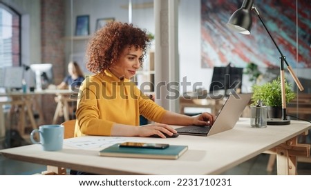 Creative Multiethnic Female Working on Laptop Computer in a Company Office. Happy Driven Project Manager Browsing Internet, Writing Tasks, Developing a Marketing Strategy for a Financial Institution.