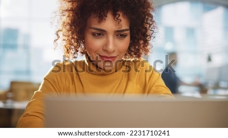Low Angle Portrait of an Expressive Multiethnic Arab Female Working on a Creative Job Position in a Advertising Company. Concentrated Manager Communicating with Colleagues, Writing a Business Plan.