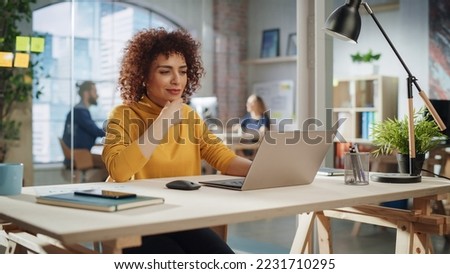 Confident Arab Female Sitting in Creative Agency, Manager Working on Implementing Modern Business Strategy for Client. Excited Specialist Writing Corporate Project Plans on Laptop Computer.