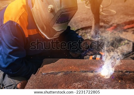 Worker wearing industrial uniforms and Welded Mask industrial safety first concept