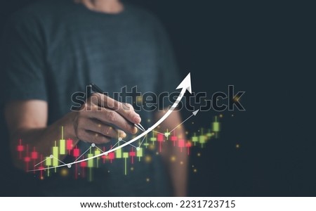 Man pointing with a pen on an upward arrow on a stock trading chart stock trend up and plan to increase stock port, business analytics and financial growth concept.