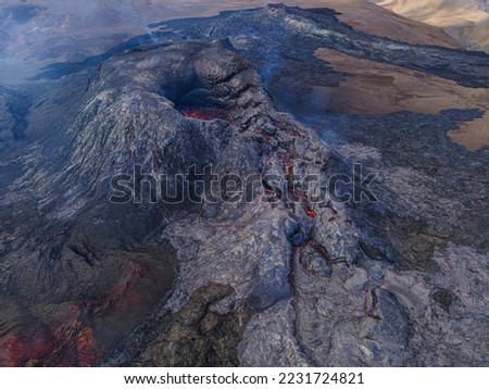Volcanic crater in Iceland. active volcano on Reykjanes peninsula by day. Dark magma rock around the crater. such as liquid lava in the crater before the eruption. Little smoke near the crater