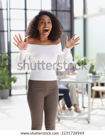 Portrait of a young attractive African American woman raised her hands up