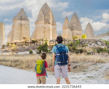 Father and son tourists on background of Unique geological formations in Love Valley in Cappadocia, popular travel destination in Turkey. Traveling with children in Turkey concept Royalty-Free Stock Photo #2231736643
