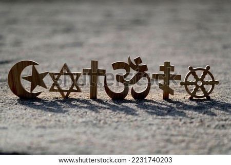 Religious symbols on sand. Christianity, Islam, Judaism, Orthodoxy Buddhism and Hinduism. Interreligious or interfaith concept.
 Royalty-Free Stock Photo #2231740203