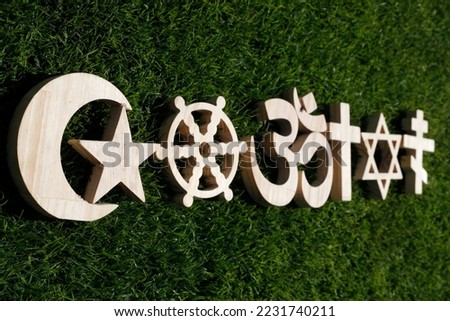Religious symbols on grass. Christianity, Islam, Judaism, Orthodoxy Buddhism and Hinduism. Interreligious or interfaith concept.
 Royalty-Free Stock Photo #2231740211