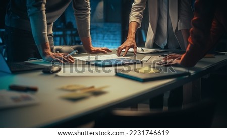 Close Up on Colleagues Discussing a New Business Opportunity, Putting Hands on a Meeting Room Table in an Office at Night. Discussing Project Plan on Tablet Computer with Development Timeline Royalty-Free Stock Photo #2231746619