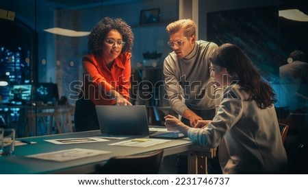 Excited Marketing Manager Leading a Team Meeting in Creative Office Conference Room in the Evening. Confident Multiethnic Female DIscussing a New Project Plan with Agency Employees. Royalty-Free Stock Photo #2231746737