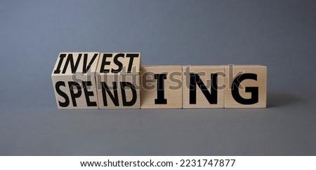 Investing and Spending symbol. Turned cubes with words Investing and Spending. Beautiful grey background. Business and Investing and Spending concept. Copy space
