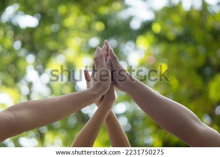 Motivated business team join hands palms together, giving high five. Successful teamwork and help support unity in common goal achievement Royalty-Free Stock Photo #2231750275