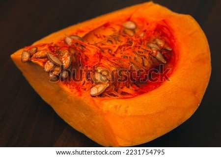 Pumpkin isolated on a dark background. Pumpkin seeds. Autumn vegetable harvest. Vegetables background. Cooking dinner. A piece of sweet pumpkin for making a pie. American food
