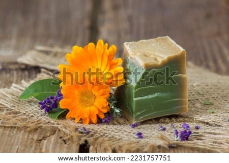 Natural handmade soap with calendula, lavender and herbs on rustic wooden background
