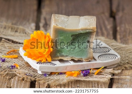 Natural handmade soap with calendula flower on rustic wooden background