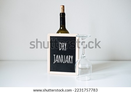 Dry January. Alcohol-free challenge, Health campaign urging people to abstain from alcohol for the January month. Bottle of wine, glass and sign with text Dry January Royalty-Free Stock Photo #2231757783