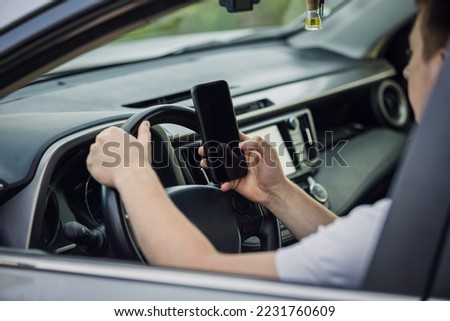Casual driver guy distracted by his phone while in front of the steering wheel, using his smartphone with one hand while driving. Risk and danger situations on the road, violating traffic rules

 Royalty-Free Stock Photo #2231760609