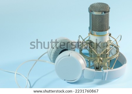 White headphones and microphone. For sound recording. on a blue background. copy space