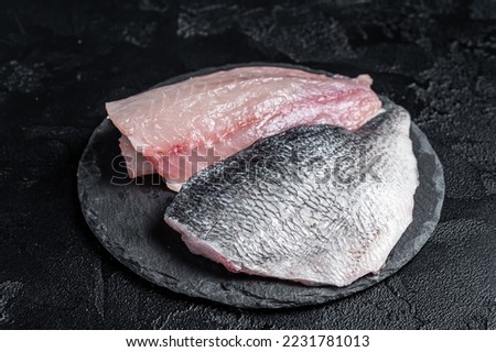 Raw Sea bream Dorado fish fillets. Black background. Top view. Royalty-Free Stock Photo #2231781013