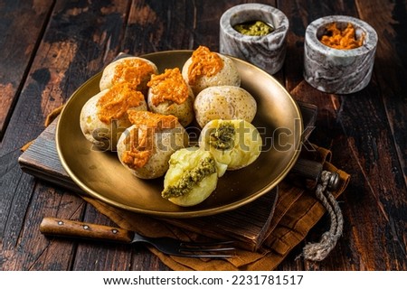 Canary Islands dish Papas Arrugadas wrinkly salty potatoes with and Mojo picon red spicy sauce. Wooden background. Top view. Royalty-Free Stock Photo #2231781517