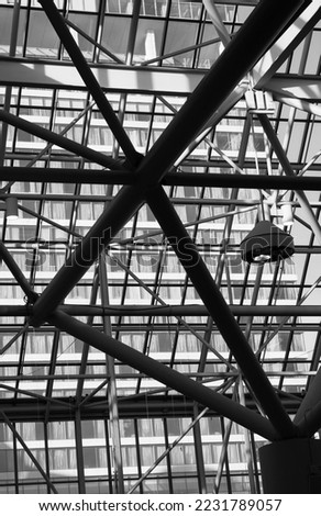 interior roof of inside of Metro Toronto Convention Centre with hanging industrial commercial light and reflection of windows in background lines and shapes and patterns in black and white vertical