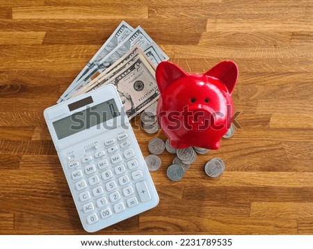 Piggy bank and calculator with coins scattered on wooden table. Saving finance money and economy concept