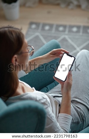 Mock up white screen blank mobile phone in woman hands holding Back view Royalty-Free Stock Photo #2231798163