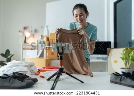 Beautiful young woman working at online store Wearing casual clothes, she checks the customer's laptop address and product information She owns a small business.