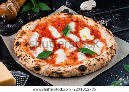 Neapolitan pizza with spices, tomatoes and cheese mozzarella on dark background. Italian cuisine pizza with mozzarella, tomato sauce, spinach on a thick dough.